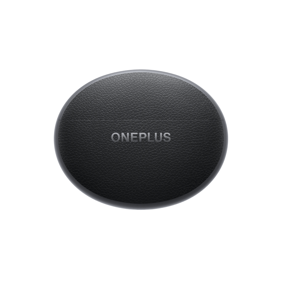 Sleek black oval OnePlus wireless charger on green background.